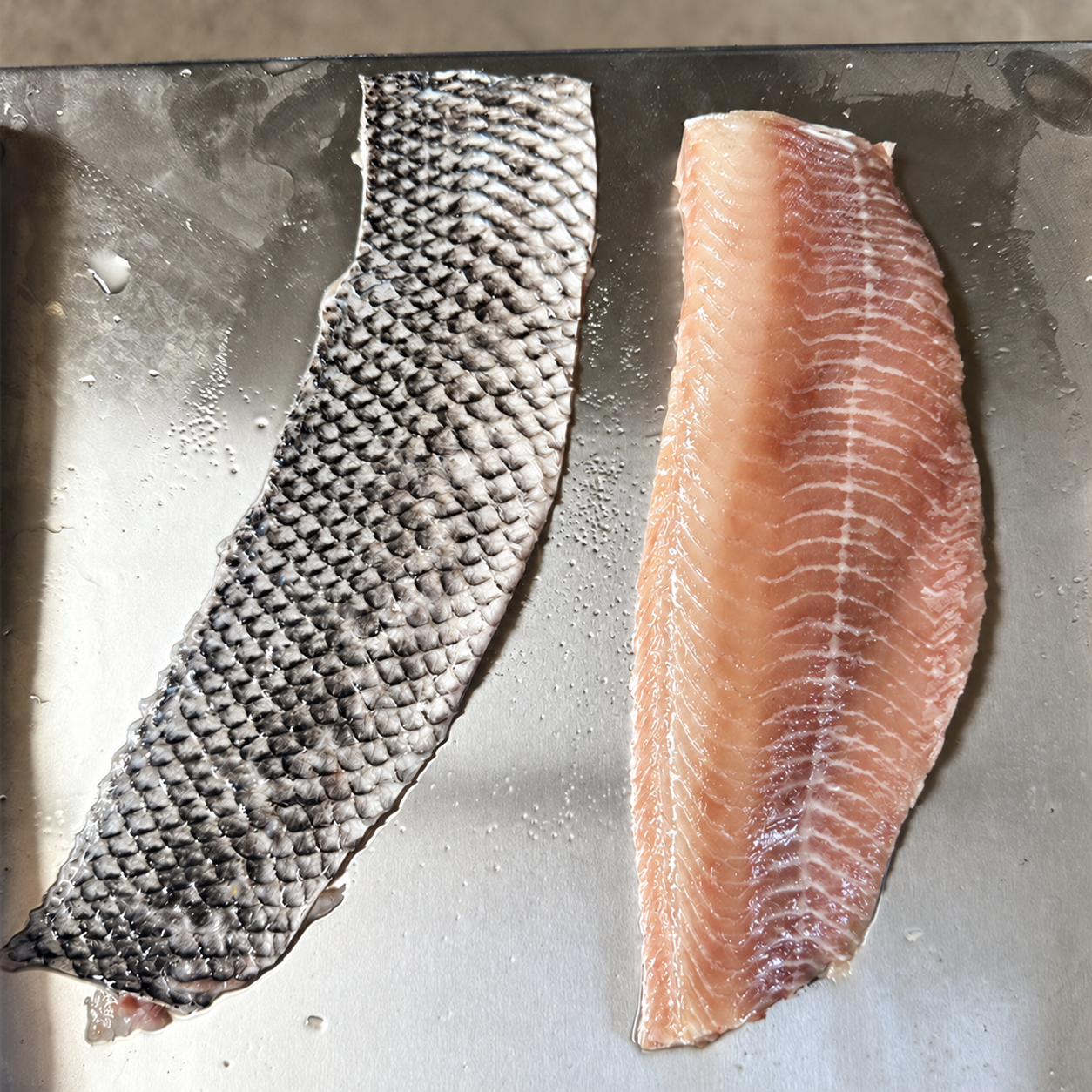 Separated fish skin and fillet placed side by side